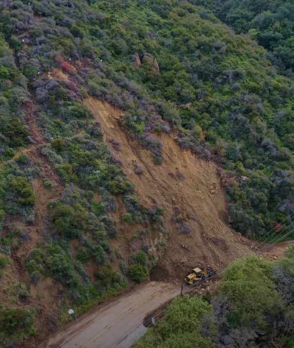 Excavator clearing a landslide on a steep hillside in Topanga Canyon